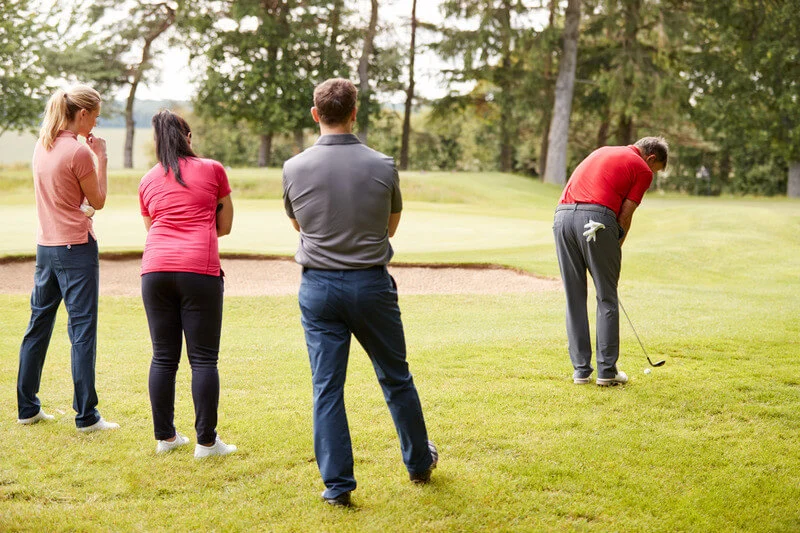 People golfing. 2 women. 2 men.