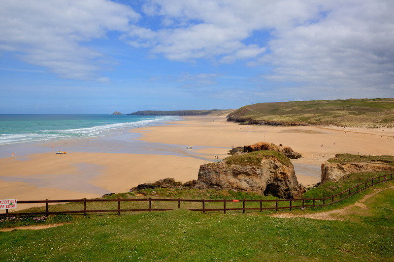 Perranporth Beach in Wales. Hills in foreground and beach + shore in background.