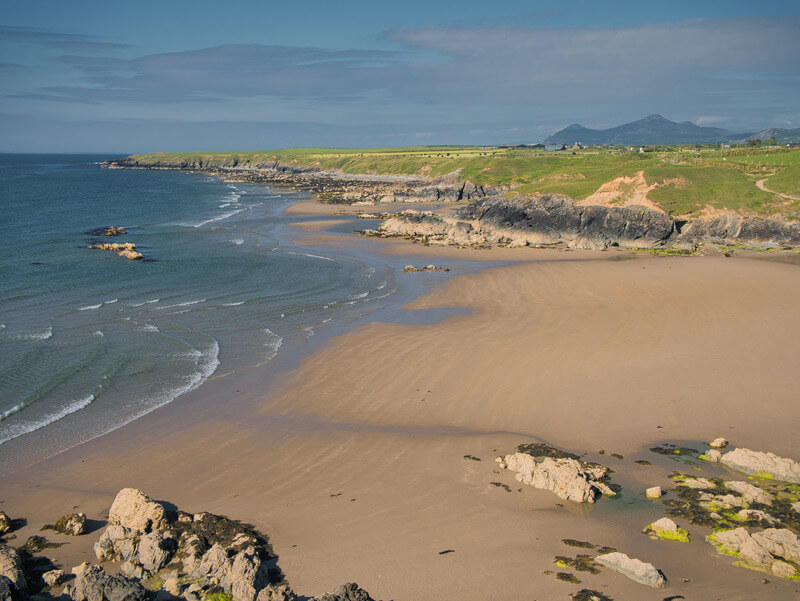 Beach in Towyn, Wales, United Kingdom. Rocks visible in background ad shore in foreground.