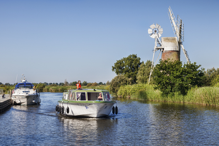 Norfolk, England, UK - Motor cruisers near Turf Fen Windmill on the Norfolk Broads.