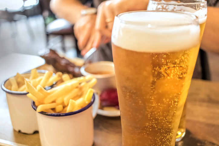 Restaurant dining, beer and barbecue food. | Pint of lager with two portions of chips in white ceramic ramekins at a haven holiday park