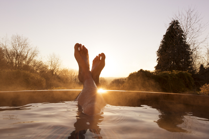 woman relaxing in outdoor forest hot tub at sunset. nature spa. banner with copy space