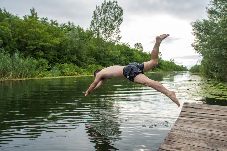 Man diving into a river, wild swimming.