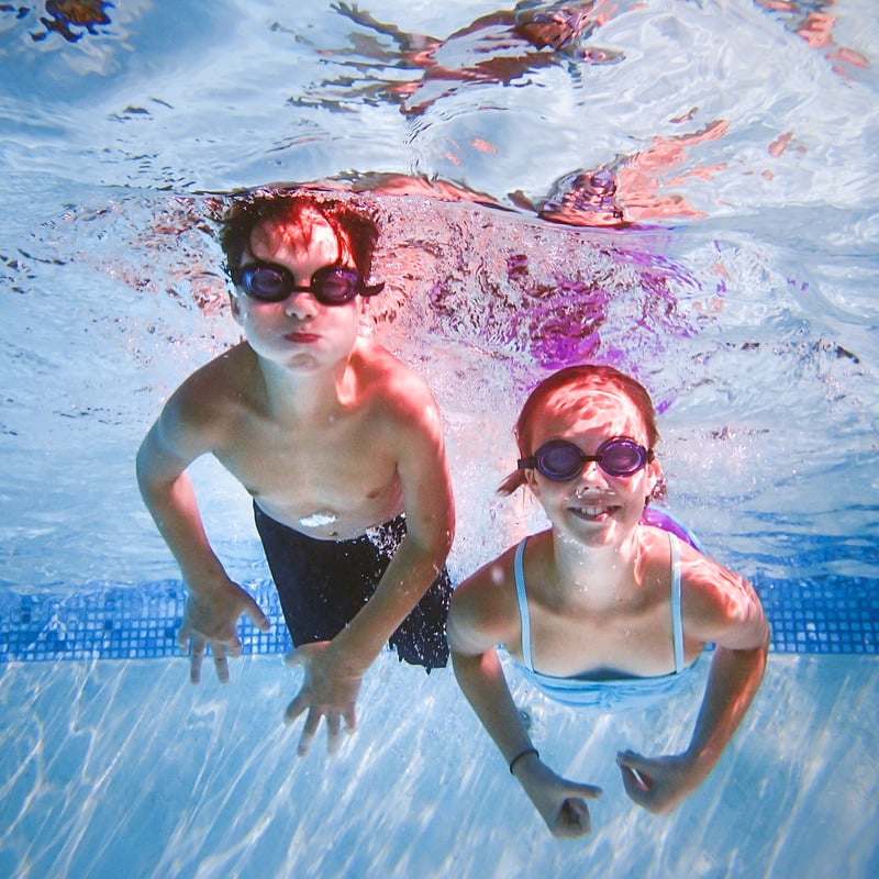 two children swimming under water with goggles on during their haven holiday