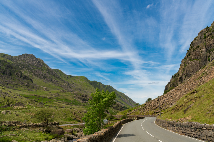 A scenic road winding through the mountainous landscape on the road to Llanberis, with Crib Goch on the left, Snowdonia, Gwynedd, Wales, UK, perfect for cycling in North Wales.