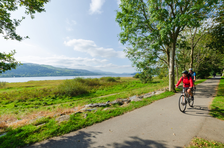 Cycling in North Wales offers breathtaking landscapes and historic sites, including the impressive Cilgerran Castle. Imagine pedaling through scenic routes, with majestic medieval castles like Cilgerran Castle standing proudly against the backdrop of the clear blue sky. The undulating terrain, coastal views, and rich heritage make North Wales a perfect destination for cycling enthusiasts looking to explore the region's natural beauty and historical landmarks. The image of cyclists riding along a serene path by a lush green landscape and tranquil waters perfectly captures the essence of a cycling adventure in this picturesque region