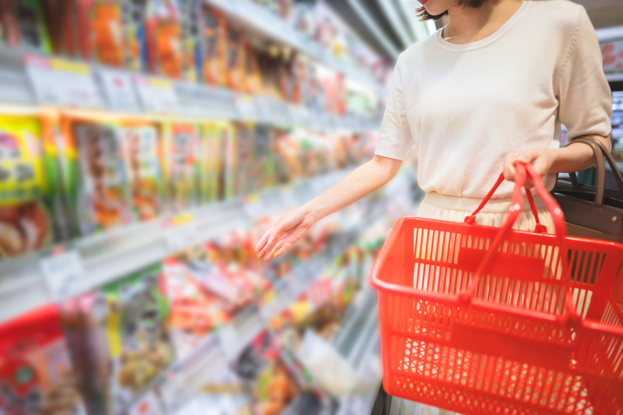 Consumer shopping at supermarket concept. Young adult asian woman customer choosing instant asia food product from shelf. Consumer buying at grocery store lifestyles.