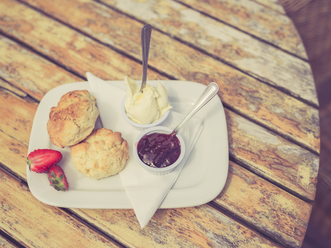 Vintage filtered shot of cream tea with scone and jam on a table