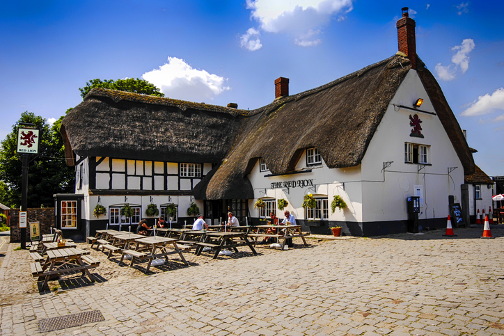 oldest pubs in England - People outside the Red Lion pub at Avebury in Wiltshire, UK