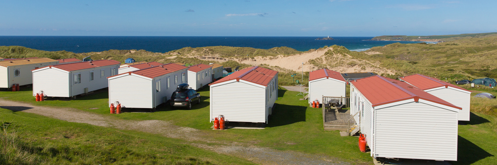 Static caravans with view to beautiful Cornish coast in summer with beautiful blue sky