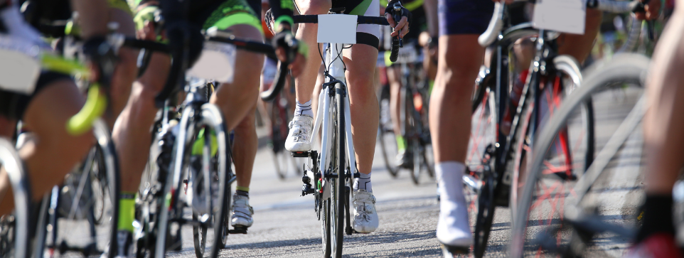 Cycling events are common in Cornwall. A peloton on cyclists. Only their lower half is visible. There are 6 or 7 riders in this shot 