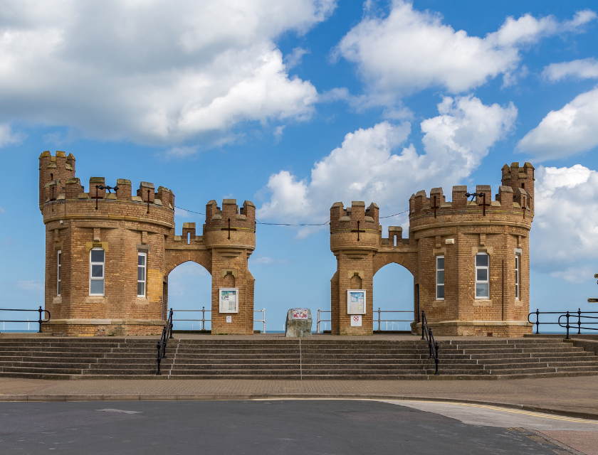 Withernsea castle infront of a bright blue sky with several clouds.