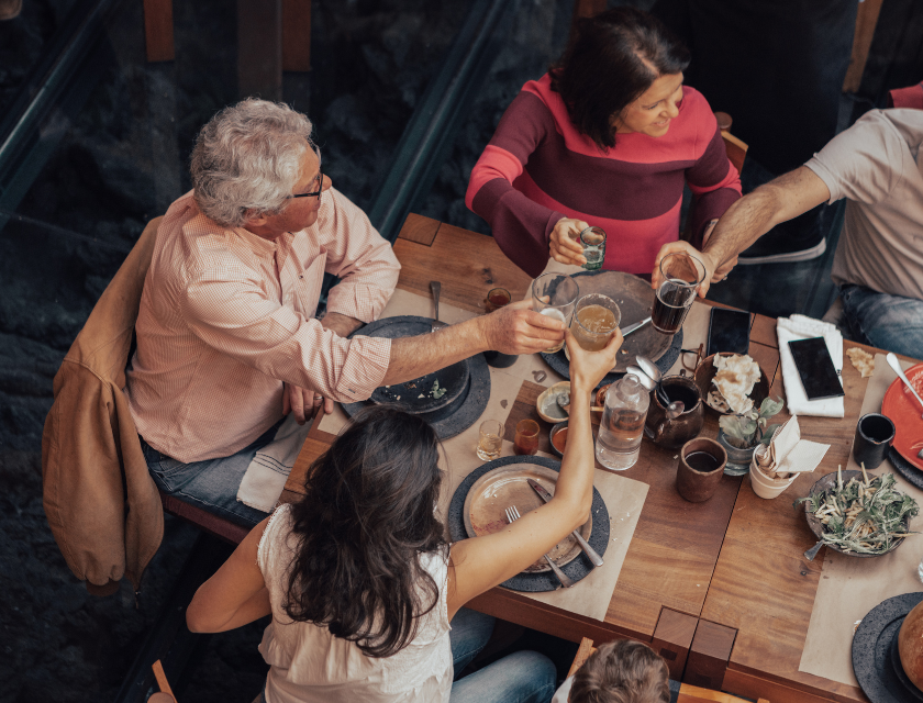 Restaurant dining is available at Trecco Bay. A group of people sitting at a table in a restaurant toasting.