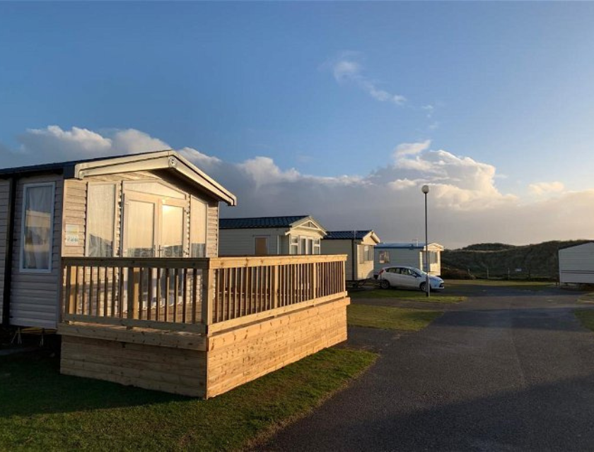 Taken in Perran Sands Holiday Park. Static caravans with outdoor decking as the sun sets.