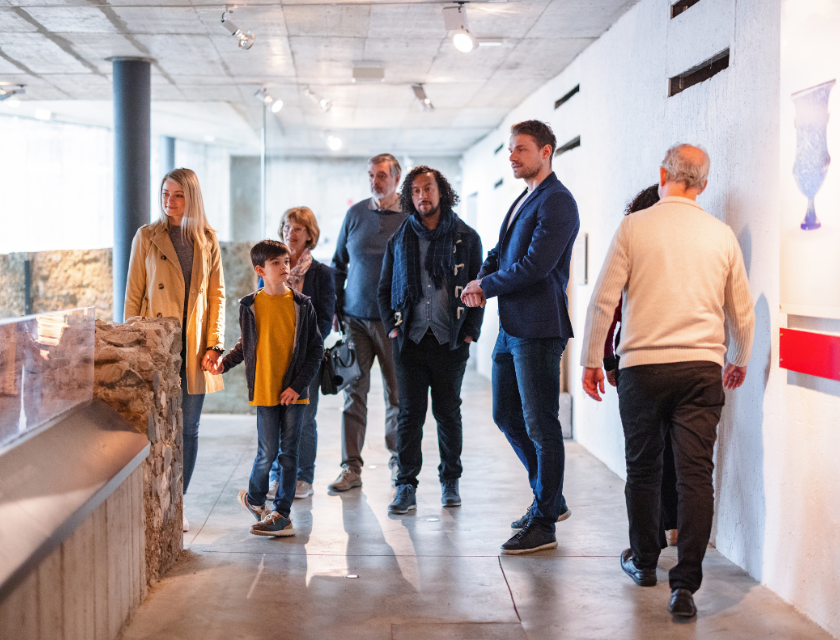 A group of people, including families, exploring a museum exhibit