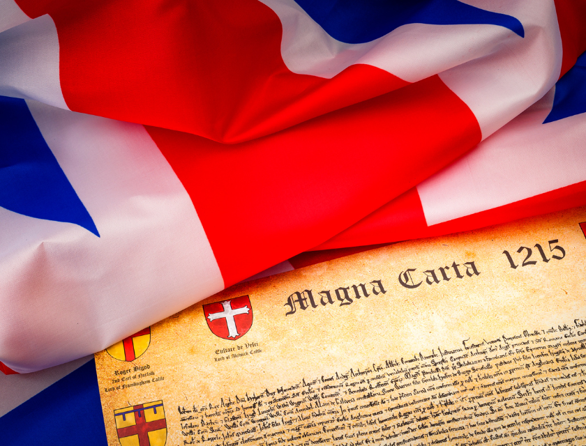 A replica of the Magna Carta lies beneath a folded Union Jack flag, highlighting the historical significance and heritage of Lincolnshire, where one of the original copies of the Magna Carta is housed.