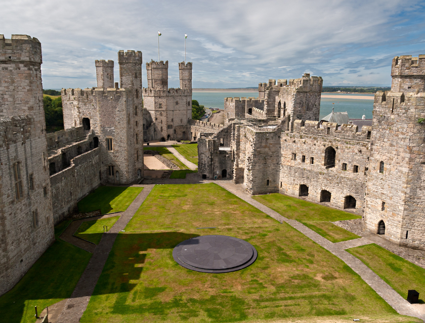 An aerial view of the majestic Conwy Castle with its imposing stone towers and walls, overlooking the scenic waters and landscape. This historic fortress, located in North Wales, offers a glimpse into the region’s rich medieval heritage.