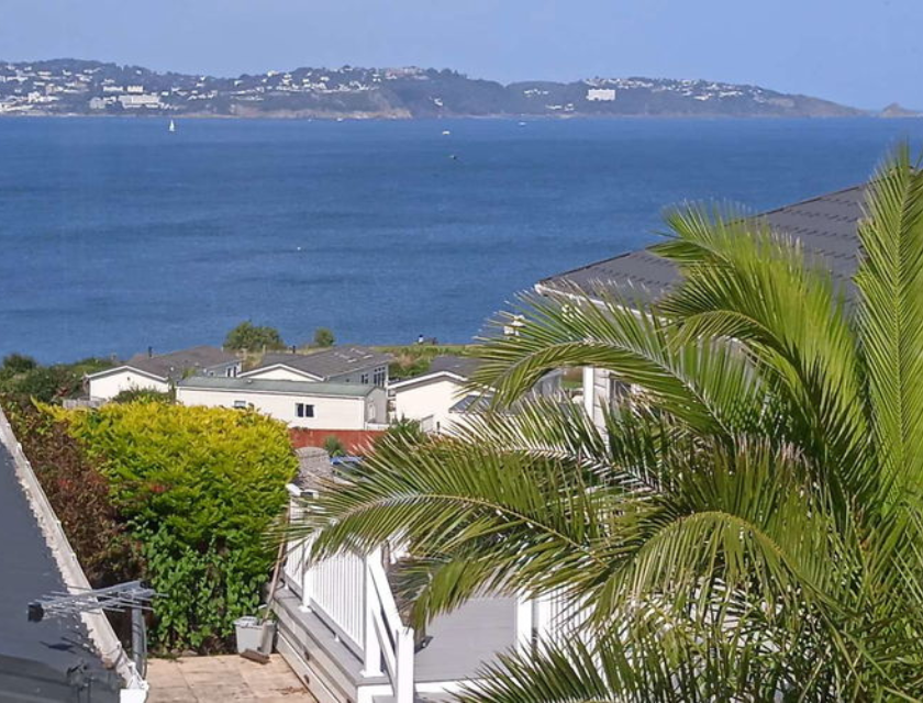 A view from a static caravan in Torquay, showing the blue sea and distant coastline, perfect for those looking for a relaxing stay with easy access to coastal walks in Torquay.