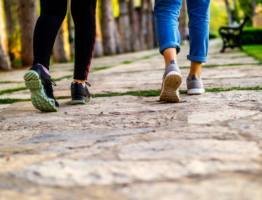 A close-up of two people walking on a stone path. 