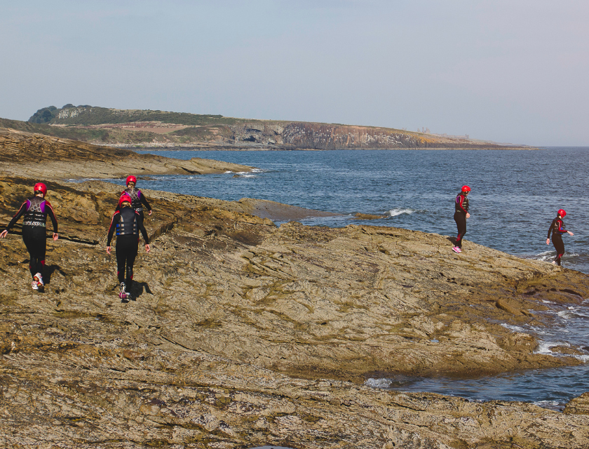 Adventurers participating in coasteering, one of the popular things to do in Croyde. The rugged shoreline offers thrilling experiences for all ages.