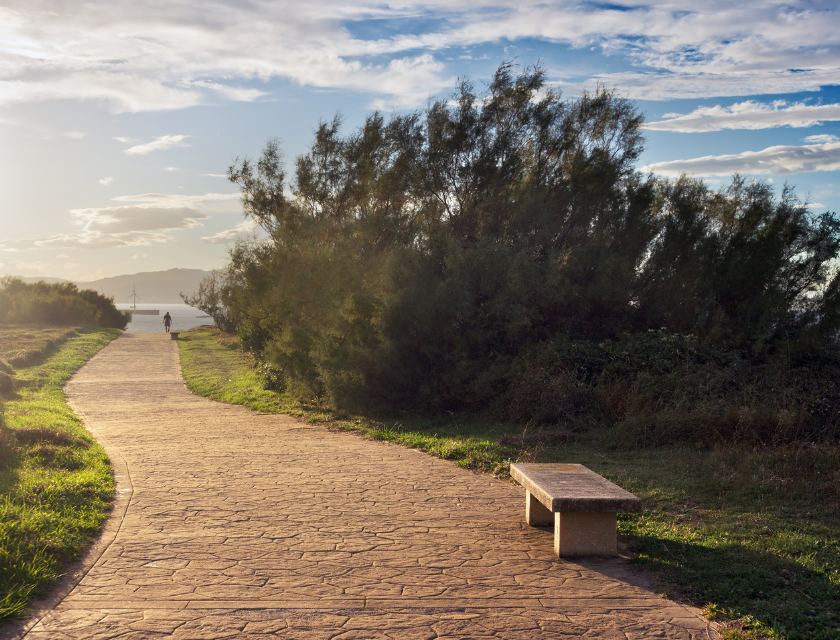 A tranquil coastal path leading to the sea, with a bench to rest and enjoy the view. Ideal for relaxing walks in Boscastle's scenic coastal routes.