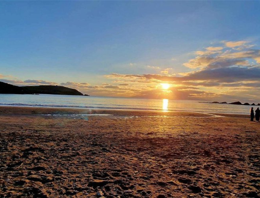 A serene sunset over a beach, capturing the beauty of South Devon’s coastline.