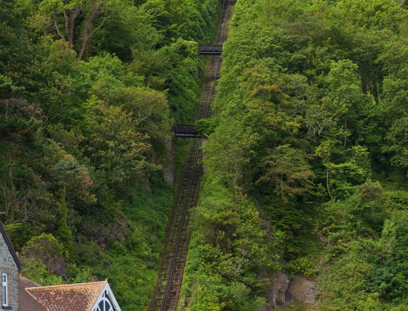 A steep, tree-lined cliff railway leading up a hill 