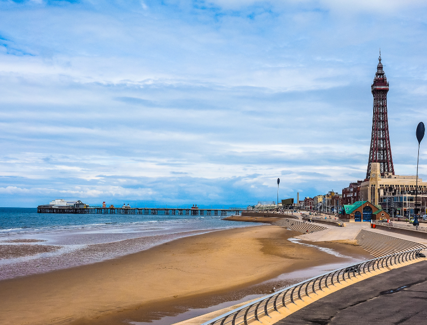 Shot of sandy Blackpool beach, with the tower and pier stretching out into the sea.