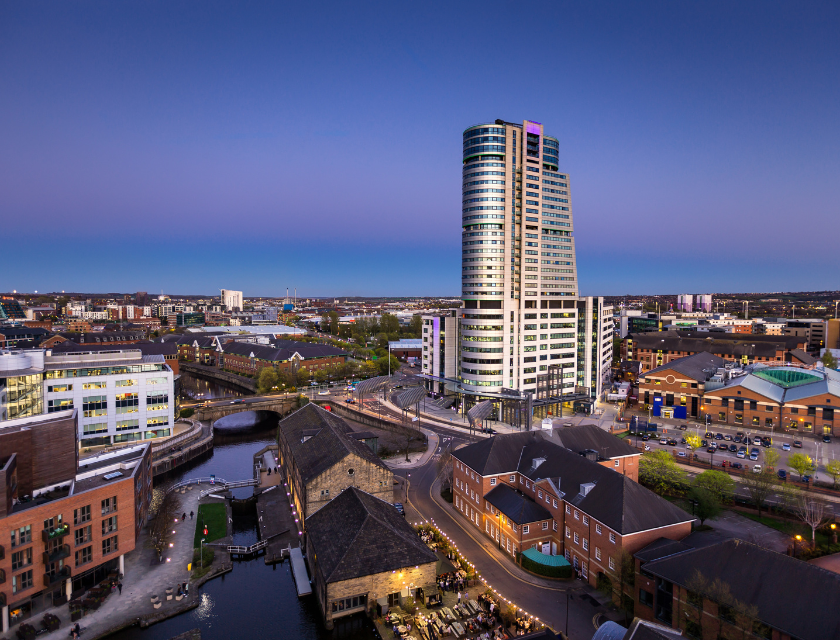 Leeds city skyline at night, featuring modern buildings.