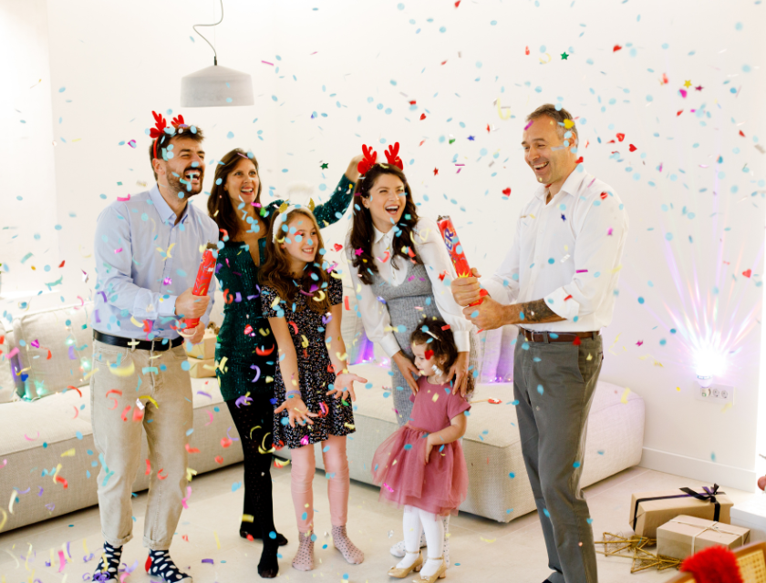 A happy family celebrating New Year's Eve at home with confetti poppers and smiles, creating a joyful and vibrant atmosphere.