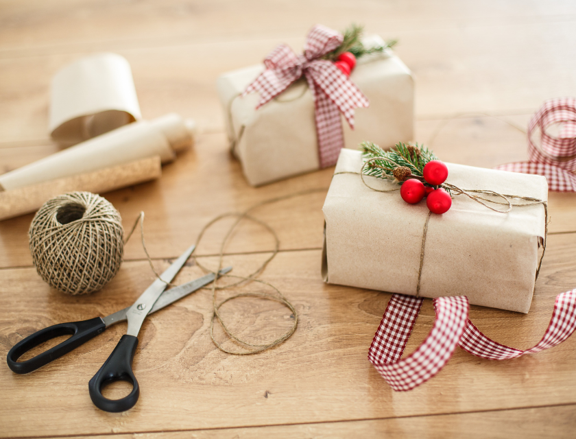 Hand-wrapped Christmas gifts with natural twine and festive decorations.