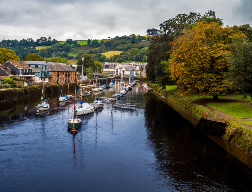 River in Totnes with boats moored in a village. A great place to enjoy Christmas markets in Devon.