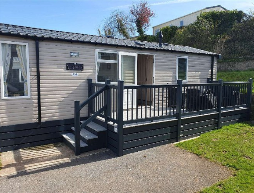 External shot of a static caravan with decking at Beverley Bay caravan park, Devon.