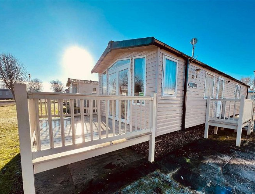 Ideal as a base for visiting the Christmas markets in Lincolnshire. External of a white caravan with decking taken on a sunny day in Lincolnshire.