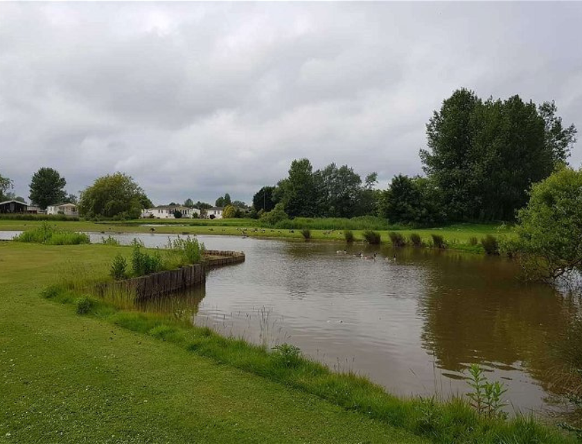 Lake surrounded by greenery at Southview Holiday Park in Lincolnshire caravan park. A perfect base for exploring Christmas markets in Lincolnshire.