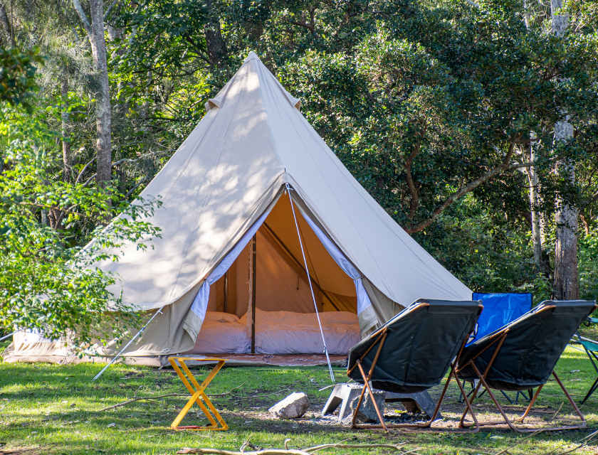 Glamping tent surrounded by greenery in the UK, offering a relaxing nature escape.