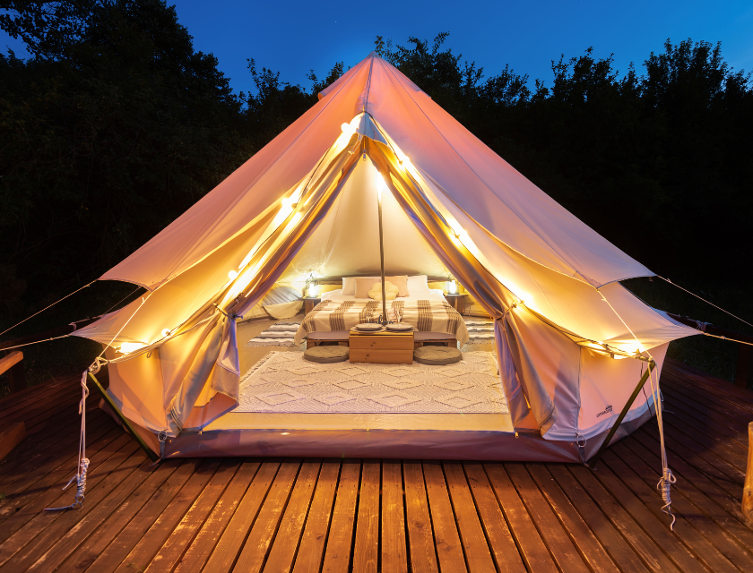 Luxury glamping tent on a wooden deck at night,. A comfortable and stylish outdoor accommodation,