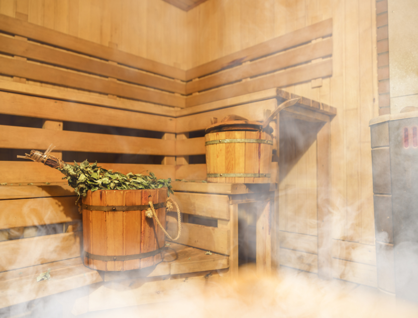 Wooden sauna with steam rising, offering a relaxing glamping experience at eco-friendly sites in the UK.