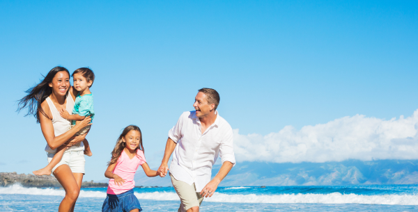 A family with two young children celebrating mother's day at the beach.